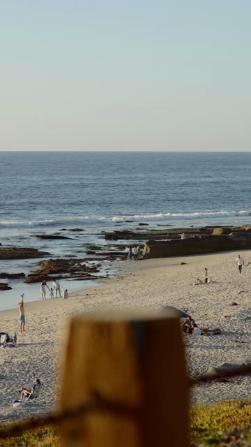 Elevated view of the beach, the surf and the ocean at Beach Barber Tract, with people walking.