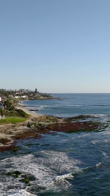 Aerial view of the cliffs, the surf and palm trees at Beach Barber Tract.