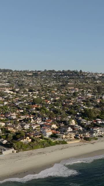 Aerial view of a residential street, the surf and the ocean at Beach Barber Tract.