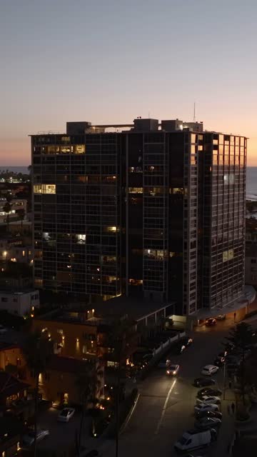 Low aerial view of a residential street, palm trees and the ocean at La Jolla Cove.