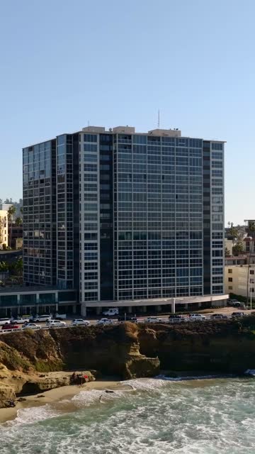 Low aerial view of the beach, the ocean and the buildings at La Jolla Cove.