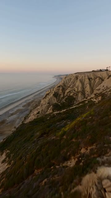 Low aerial view of the cliffs, the ocean and the beach at Black’s Beach.