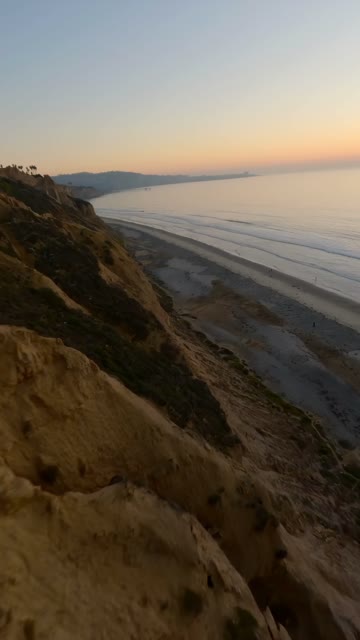 Low aerial view of the cliffs, the ocean and the beach at Black’s Beach.