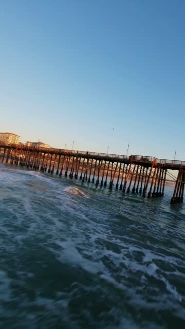 View from the water of the beach, the surf and the pier in Oceanside.