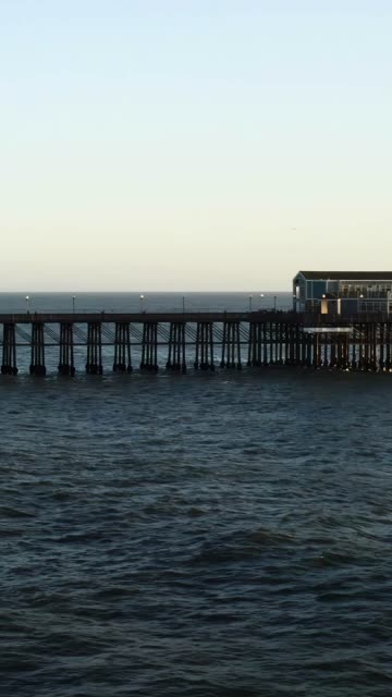 Low aerial view of the beach, the pier and the ocean in Oceanside.