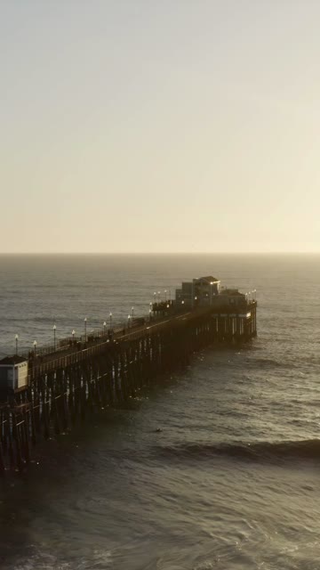 Low aerial view of the beach, the pier and the ocean in Oceanside.