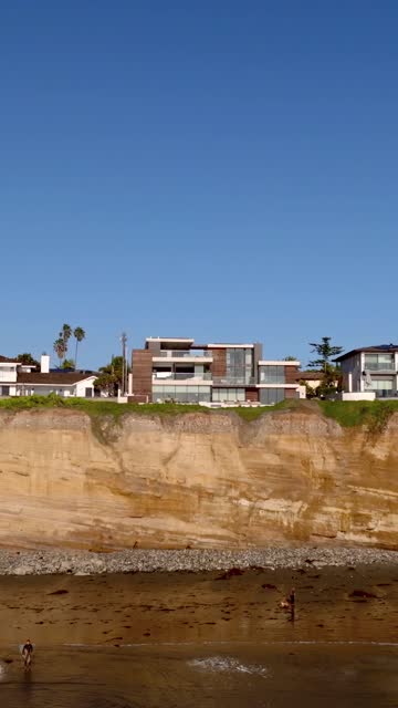 Elevated view of the cliffs, palm trees and homes at Tourmaline, with people walking.