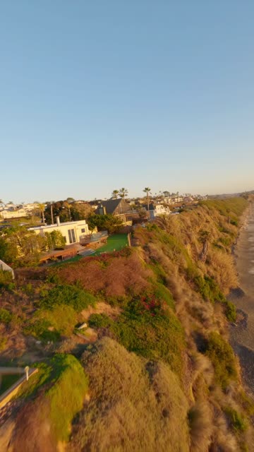 FPV drone video flying above Swamis Beach in Encinitas California showcasing the iconic surf break ocean waves and coastal cliffs on a sunny afternoon