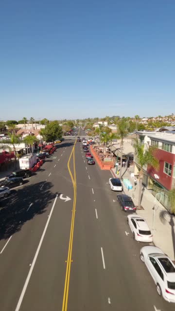Low aerial view of the downtown streets, palm trees and homes at Downtown Encinitas.