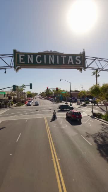 FPV drone video flying over downtown Encinitas California showing coastal streets shops palm trees and neighborhood views on a sunny afternoon