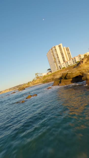 View from the water of the cliffs, the ocean and homes at La Jolla Cove.