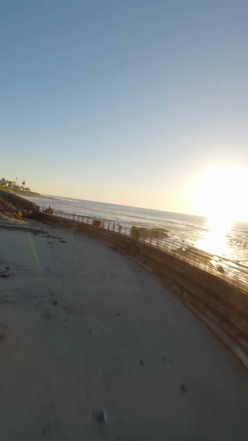 Low aerial view of the beach, the surf and the ocean at La Jolla Cove.