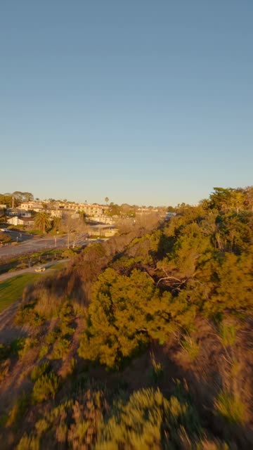 Low aerial view of a residential street, homes and traffic at Moonlight Beach.