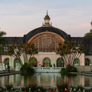 Photo of the Botanical Building and Lily Pond in Balboa Park San Diego captured during sunset showcasing historic wooden architecture warm evening light and reflections on the water | Photo - 3