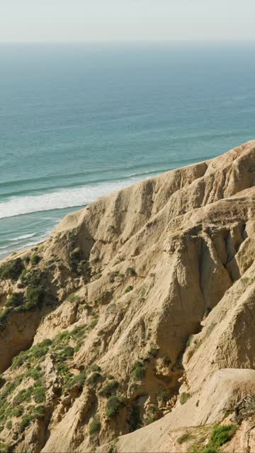 Elevated view of the cliffs, the surf and the ocean at Black’s Beach.