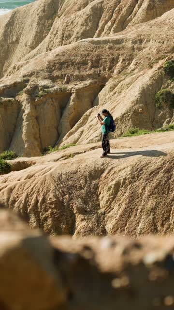 Elevated view of the cliffs and open country at Black’s Beach, with people walking.