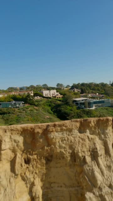 Low aerial view of the cliffs, homes and the buildings at Black’s Beach.
