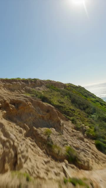 Low aerial view of the cliffs, the ocean and open country at Black’s Beach.