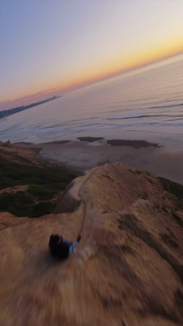 Low aerial view of the cliffs, the ocean and the beach at Black’s Beach.