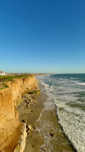 Aerial view of the cliffs, the surf and the ocean in Carlsbad.