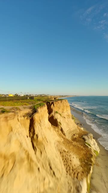 Low aerial view of the cliffs, the ocean and the beach in Carlsbad.