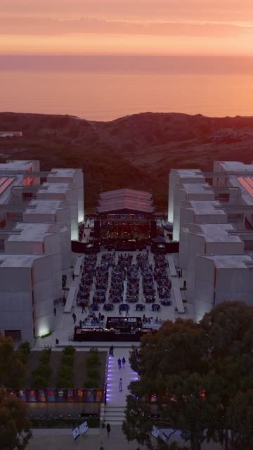Aerial view of the cliffs, the ocean and the buildings at Black’s Beach, with a crowd gathered.