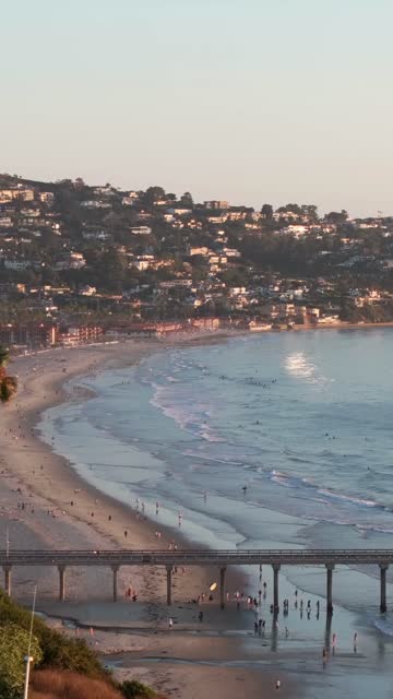 Aerial view of the beach, the surf and the pier at La Jolla Shores, with people walking.