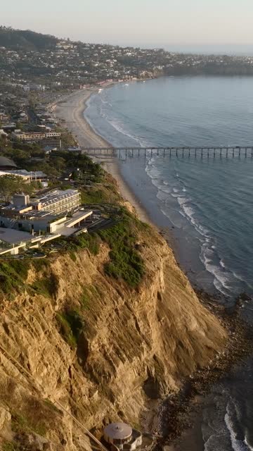 Aerial view of the cliffs, the surf and the pier at La Jolla Shores.