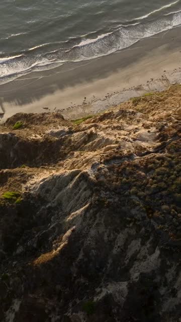 Aerial view of the cliffs, the surf and the ocean at Black’s Beach.
