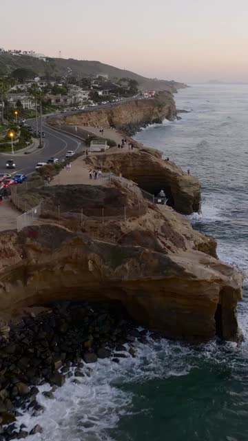 Aerial view of the cliffs, the ocean and traffic at Sunset Cliffs, with people walking.