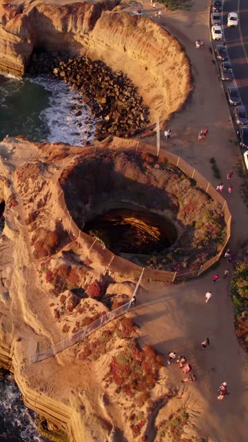 Aerial view of the cliffs, the ocean and traffic at Sunset Cliffs, with people walking.