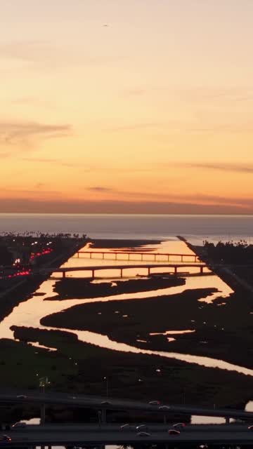 Sunset aerial drone video overlooking the San Diego River channel and ocean horizon over Mission Valley | Vertical Drone Video