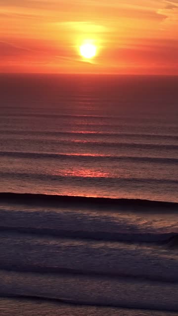 Low aerial view of the beach, the surf and the ocean at Sunset Cliffs.
