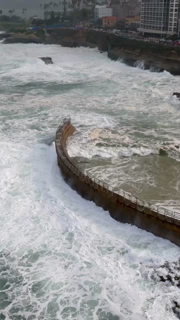 Aerial view of the cliffs, the surf and the ocean at La Jolla Cove.