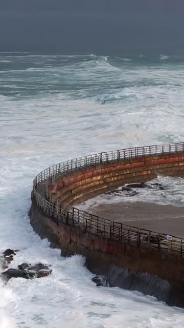 Low aerial view of the cliffs, the surf and the ocean at La Jolla Cove.