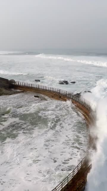 Aerial view of the cliffs, the surf and the ocean at La Jolla Cove.
