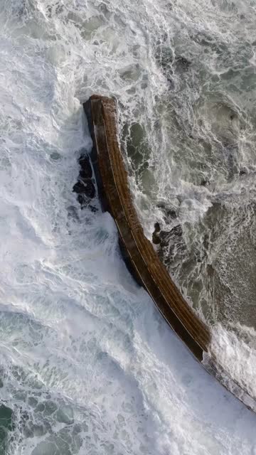 Aerial view of the cliffs, the surf and the ocean at La Jolla Cove.