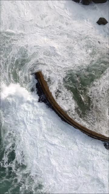 Aerial view of the cliffs, the surf and the ocean at La Jolla Cove.