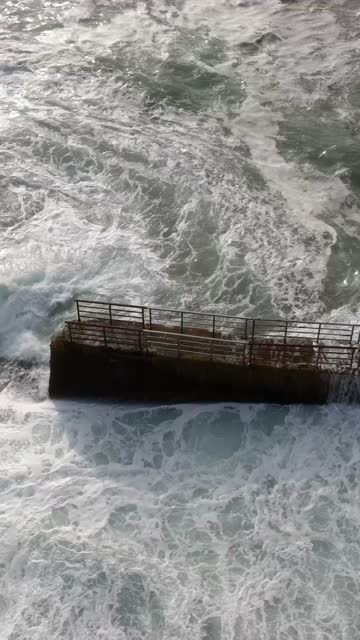 Low aerial view of the cliffs, the surf and the ocean at La Jolla Cove.