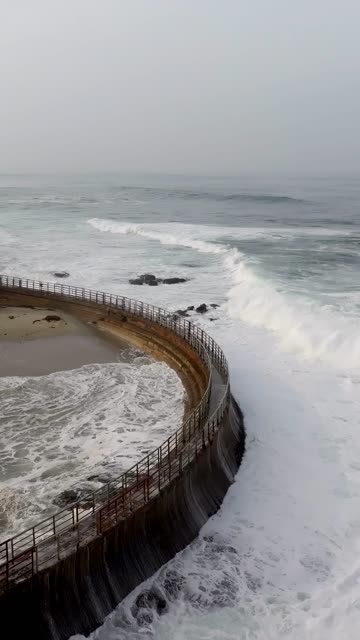 Aerial view of the cliffs, the surf and the ocean at La Jolla Cove.