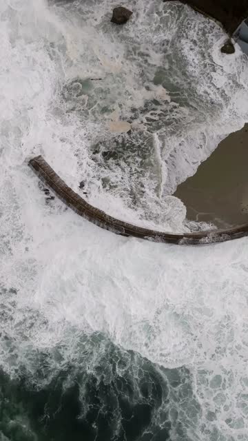 Aerial view of the cliffs, the surf and the ocean at La Jolla Cove.