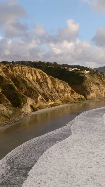 Aerial view of the cliffs, the surf and the ocean at Black’s Beach.