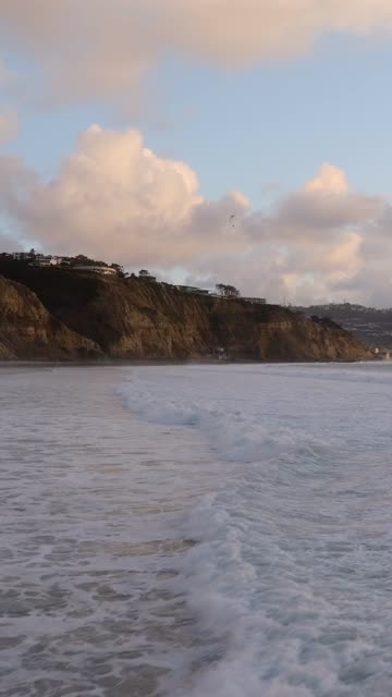 Low aerial view of the beach, the surf and the ocean at Black’s Beach.