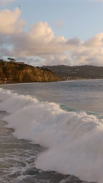 Low aerial view of the beach, the surf and the ocean at Black’s Beach.