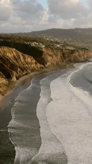 Aerial view of the cliffs, the surf and the ocean at Black’s Beach.