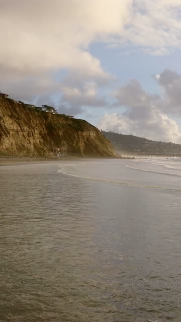 Low aerial view of the beach, the surf and the ocean at Black’s Beach.