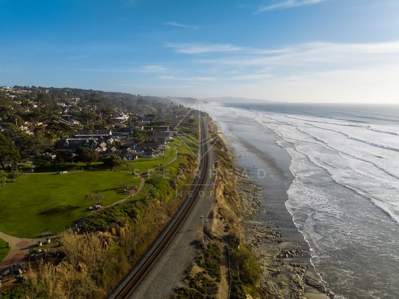 Aerial view of the cliffs, the surf and palm trees in Del Mar.