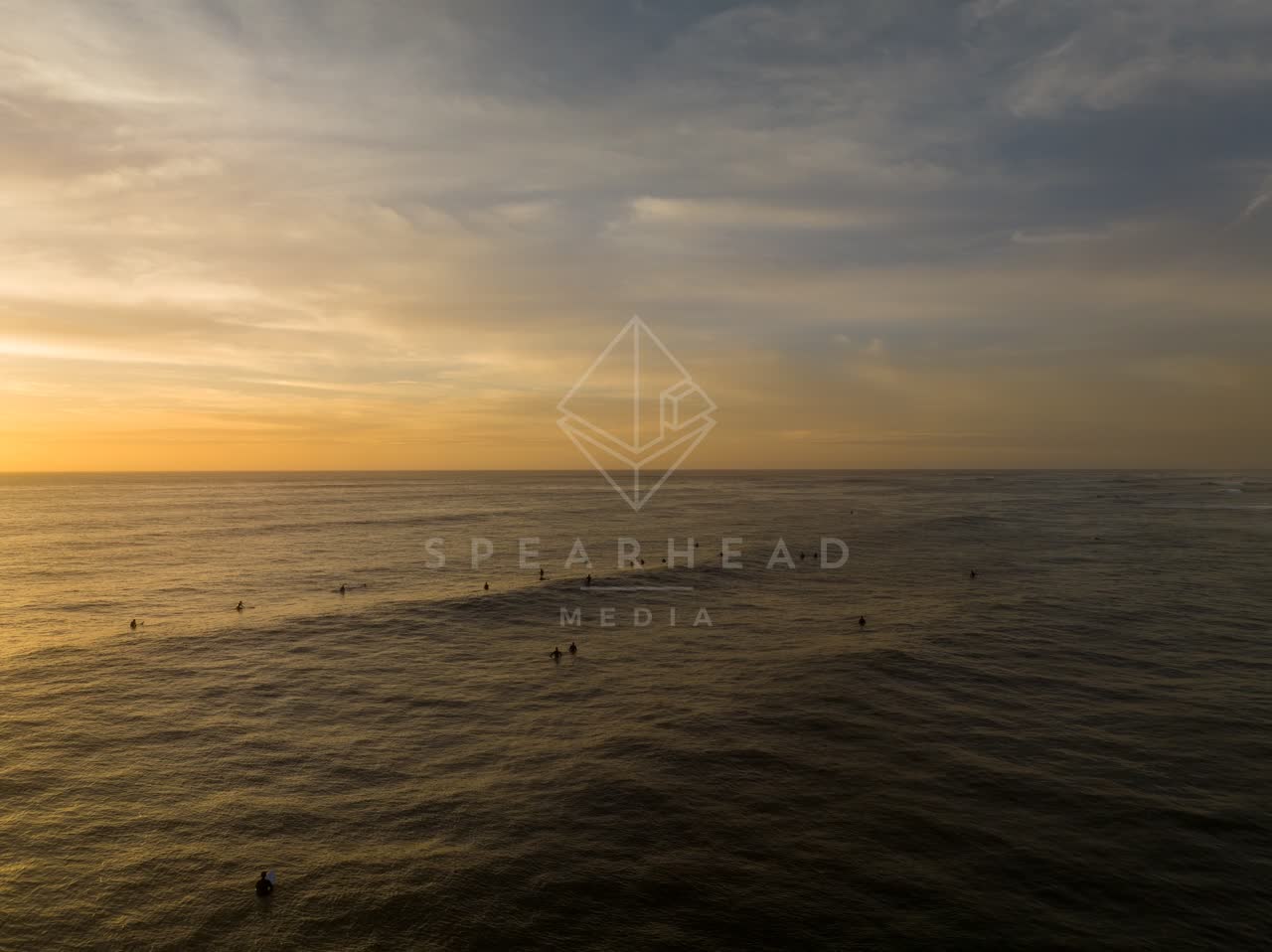 Low aerial view of the beach, the surf and the ocean in Pacific Beach, with surfers out.