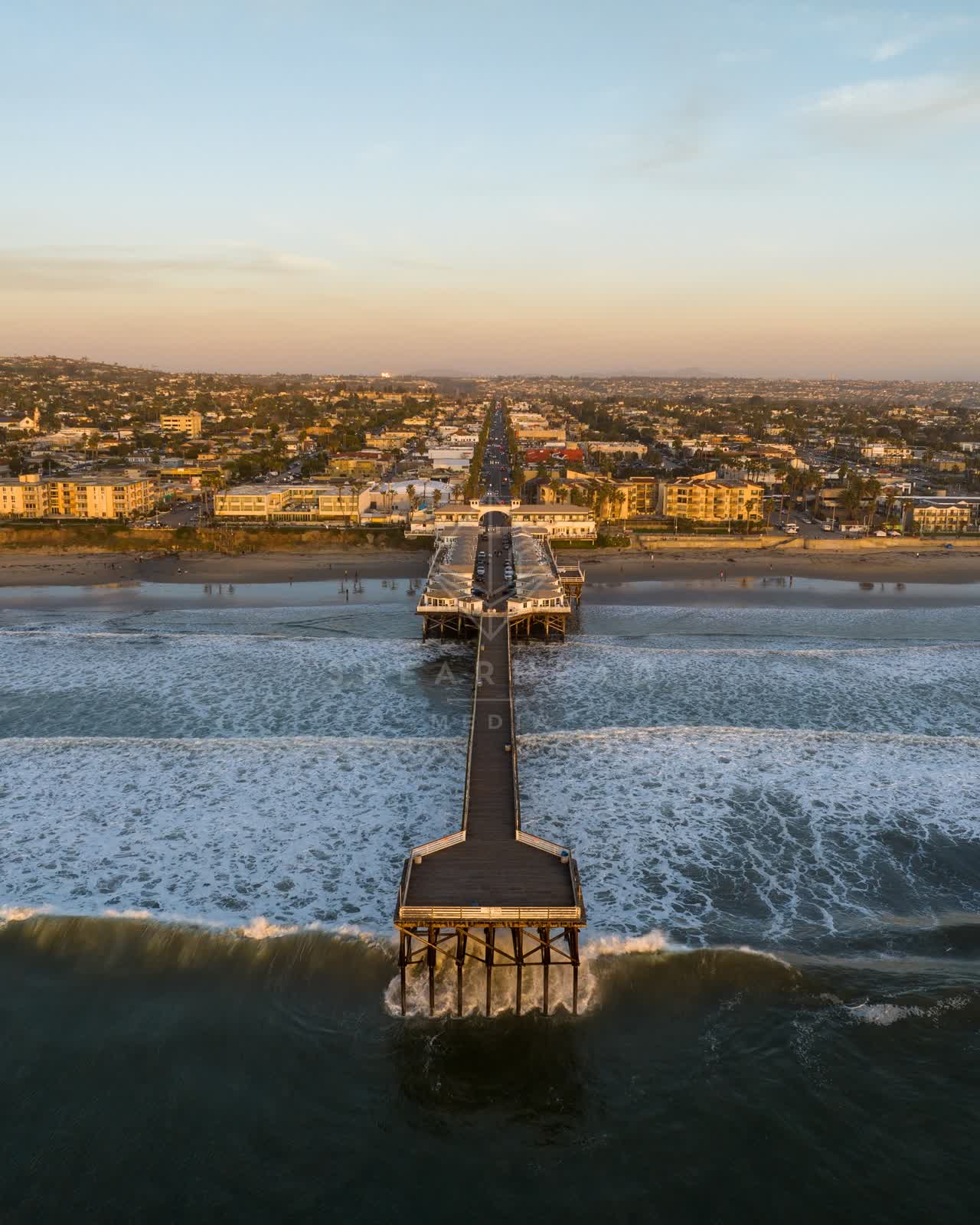 Aerial view of the beach, the surf and the pier in Pacific Beach.
