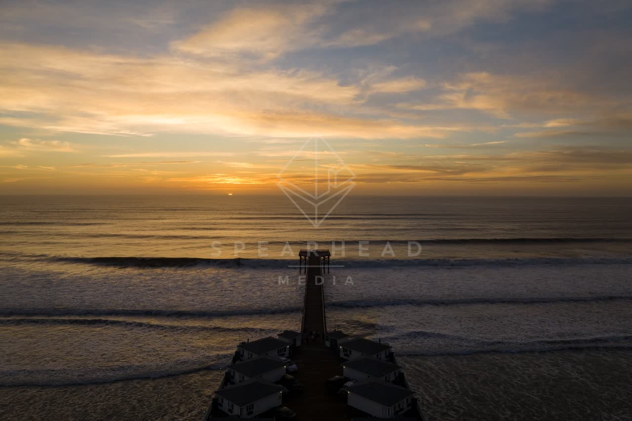 Low aerial view of the beach, the surf and the pier in Pacific Beach.